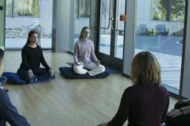 Participants sitting with their legs crossed on meditation pillows, eyes closed, hands placed on their laps. Participants sitting with their legs crossed on meditation pillows, eyes closed, hands placed on their laps.